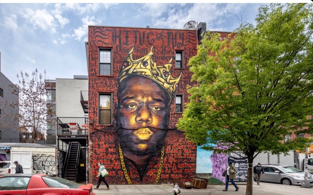 A crowned portrait mural on the side of a brick building in Brooklyn